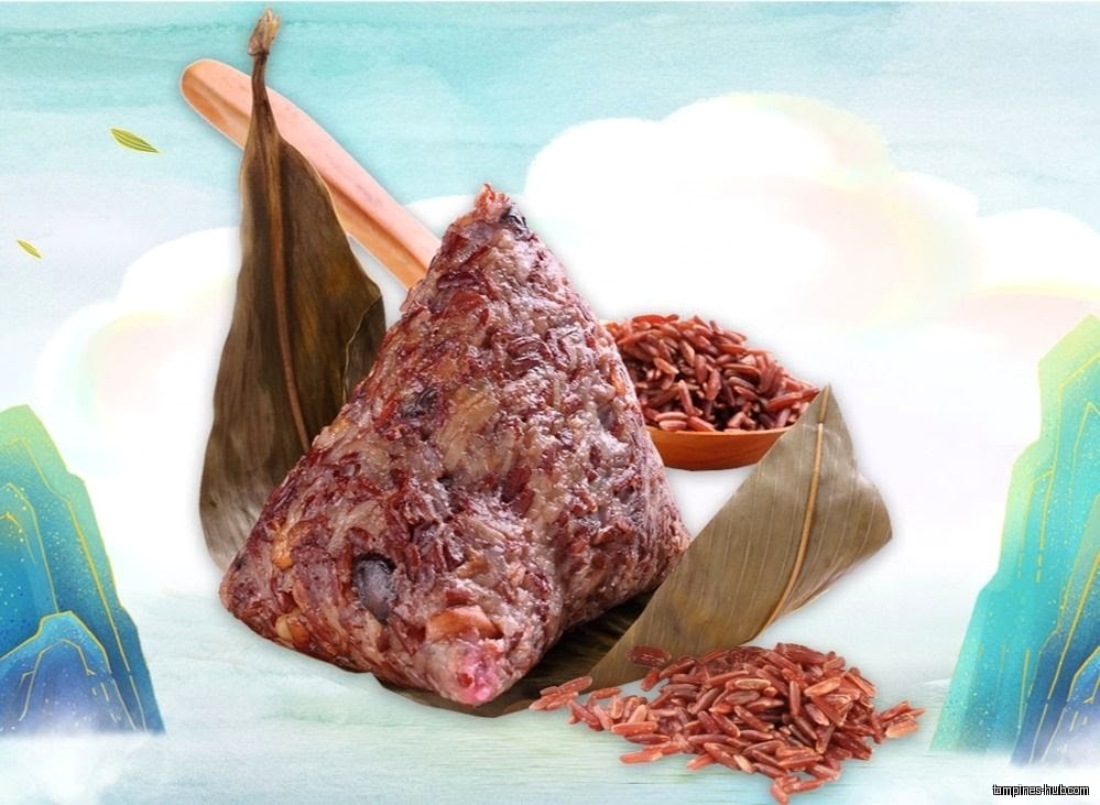 A close-up of a zongzi with red rice and bamboo leaves.