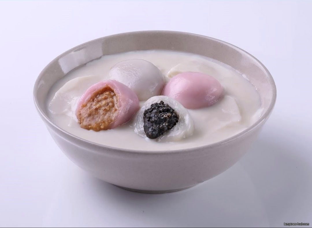 A bowl of Tangyuan dessert with different fillings in a milky broth.