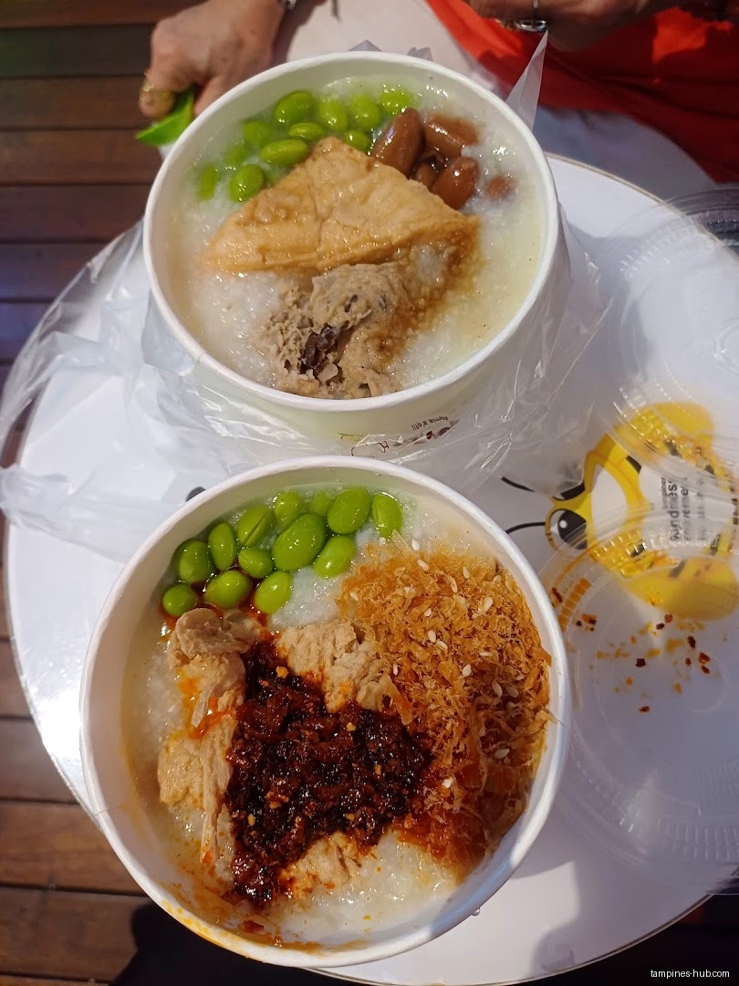 Two bowls of Mr Bean porridge with various toppings on a table.