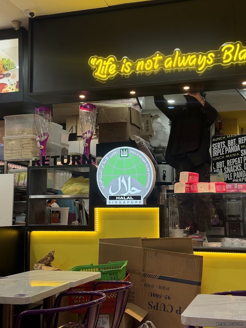 Interior shot of Munch Mania with Halal certification and a neon sign.