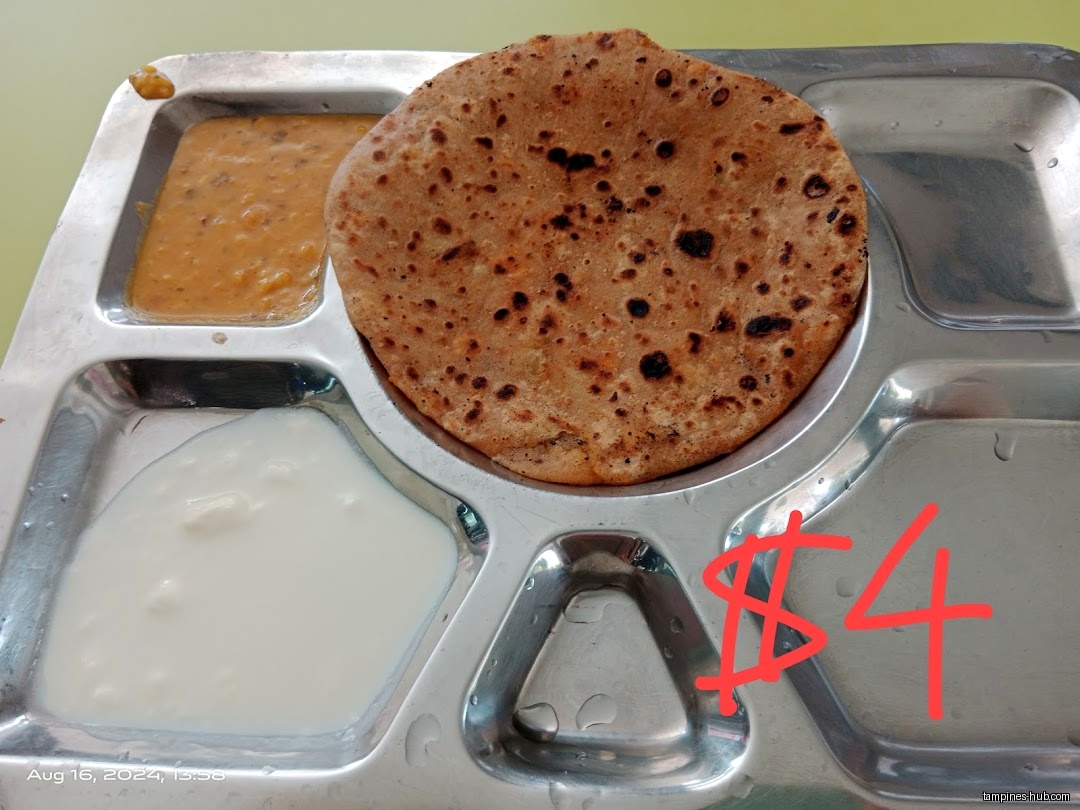 A metal tray holds dal, yogurt, and a roti, marked with a price.