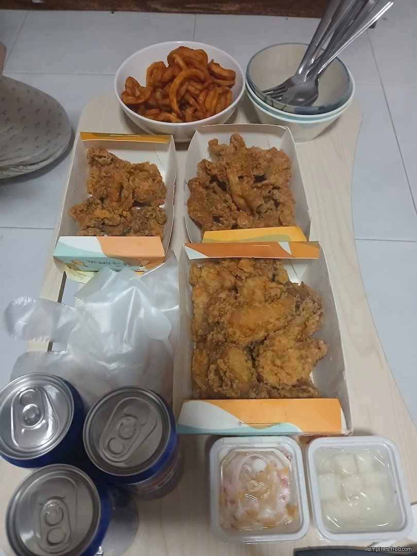A spread of NeNe Chicken food including fried chicken, fries, and drinks.