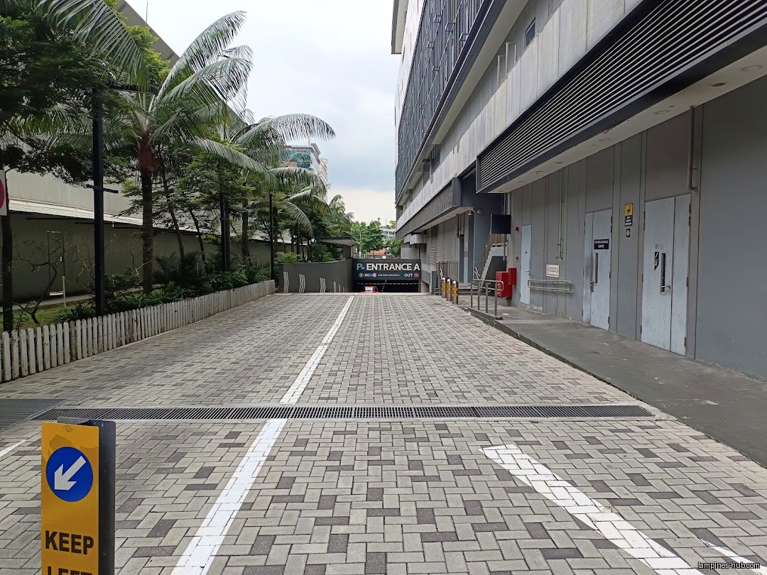 A paved driveway leads to a parking entrance at North Plaza.