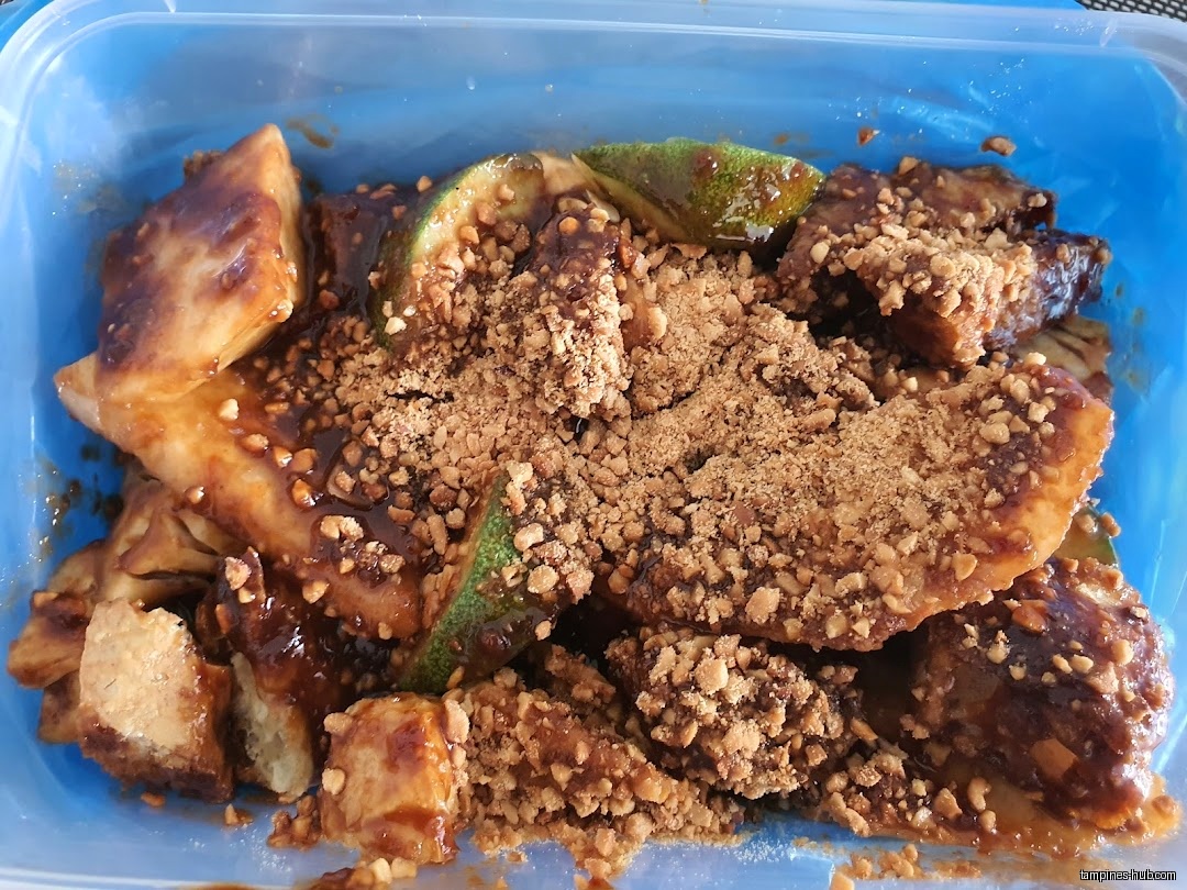 A container of Rojak, a Southeast Asian salad with peanut sauce.