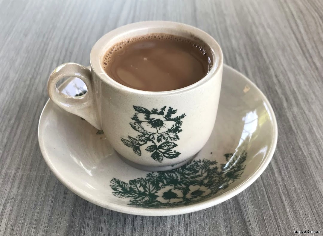 A cup of coffee with floral design on a matching saucer.