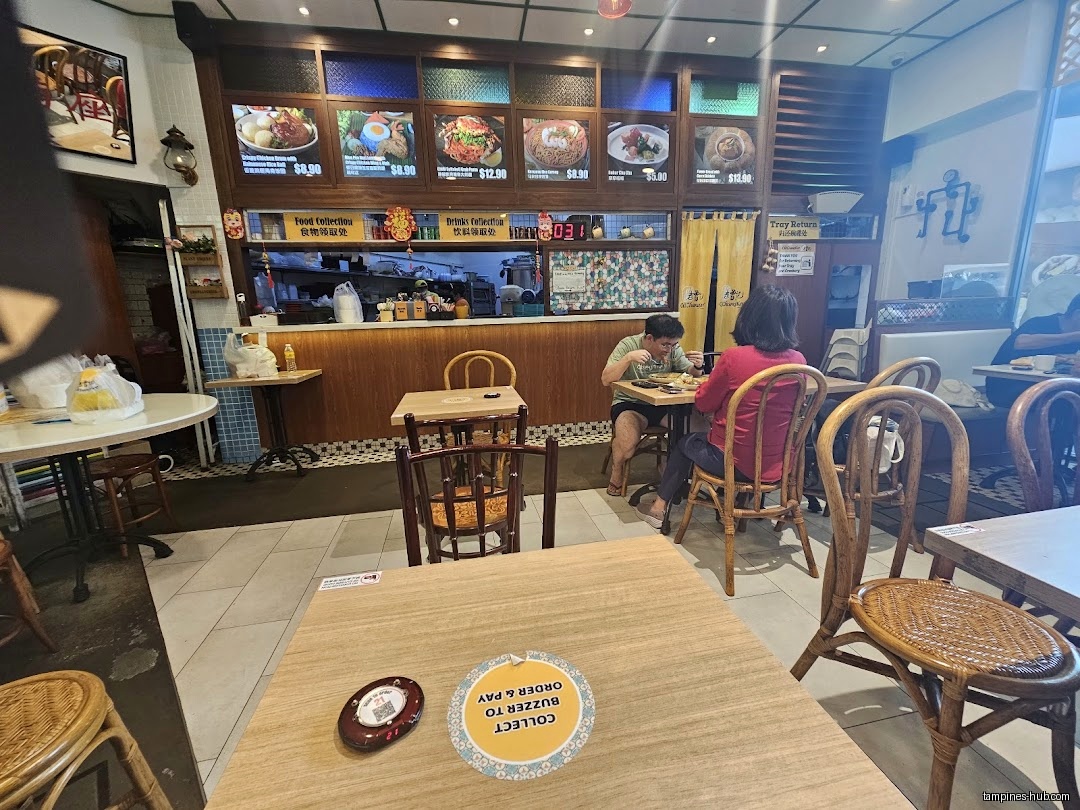 Interior view of Old Chang Kee Coffee House with customers and menu.