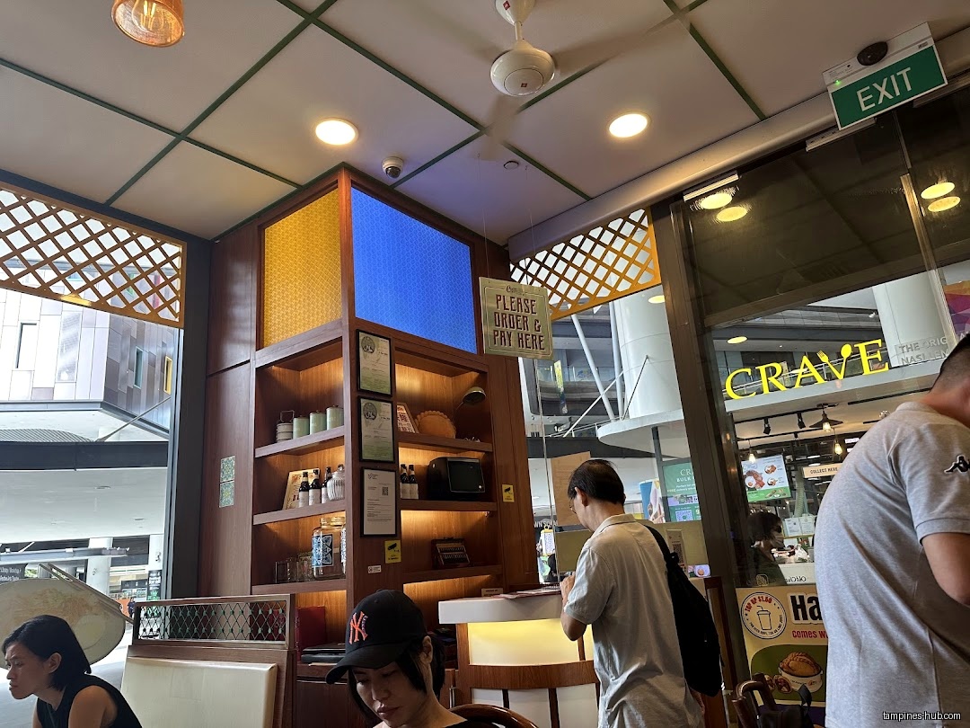 Interior view of Old Chang Kee Coffee House with customers and shelves.