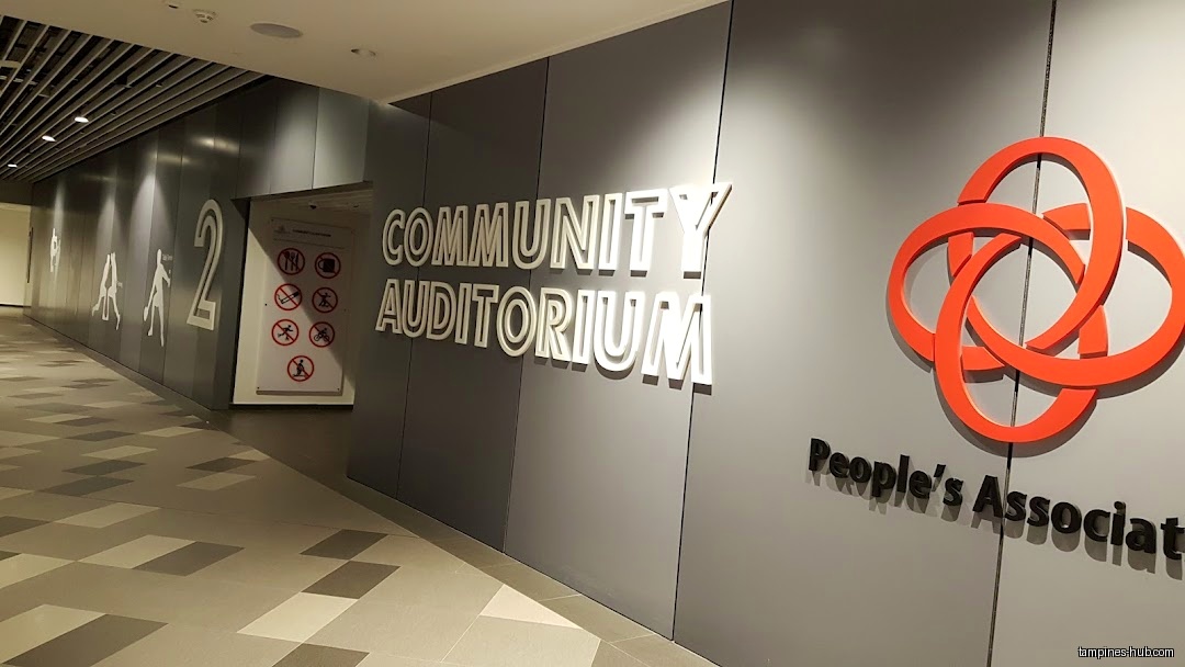 Image shows the entrance to the Community Auditorium with signage and symbols.