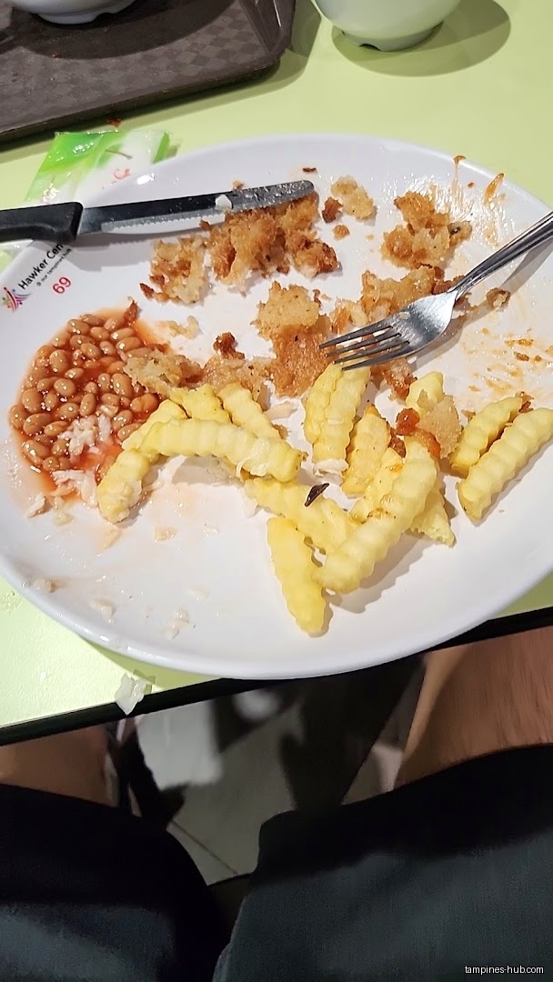A plate with leftover fries, beans, and fried food scraps.