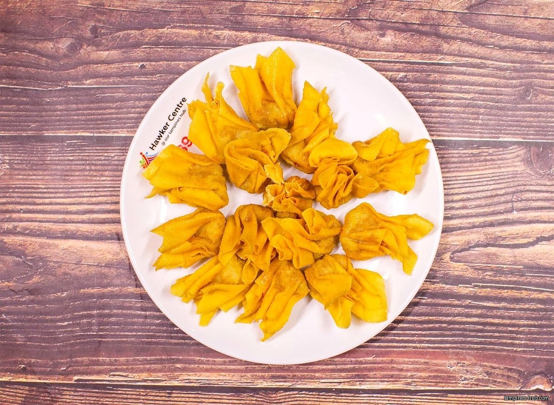 A plate of fried wontons on a wooden table.