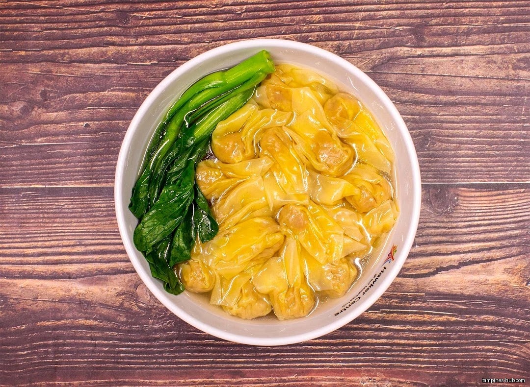 A bowl of Pang Pang Wanton Noodle soup with green vegetables.