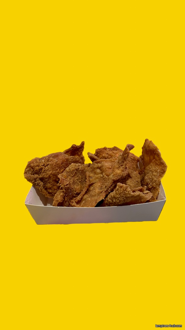 A white container holds fried chicken pieces against a yellow background.