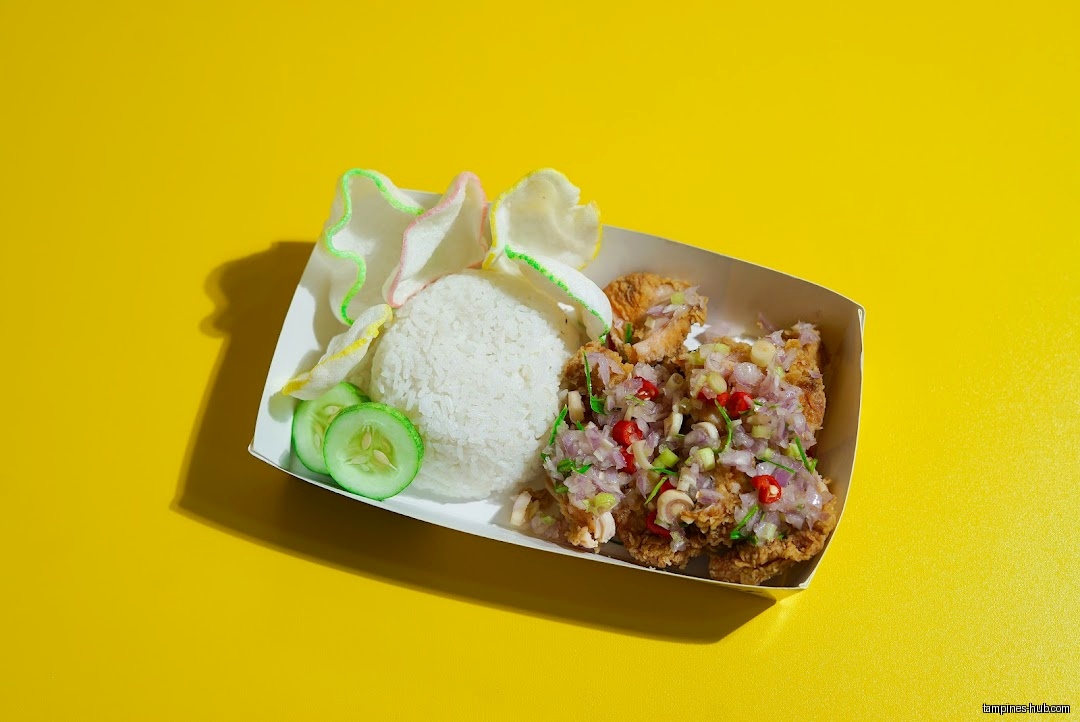 Ayam Geprek dish with rice, crackers, and cucumber on a yellow background.