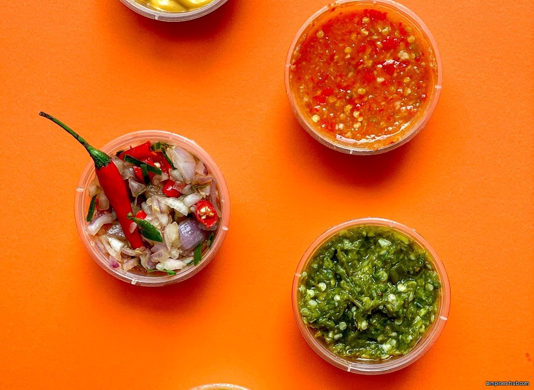 Overhead shot of four small containers of different chili sauces.
