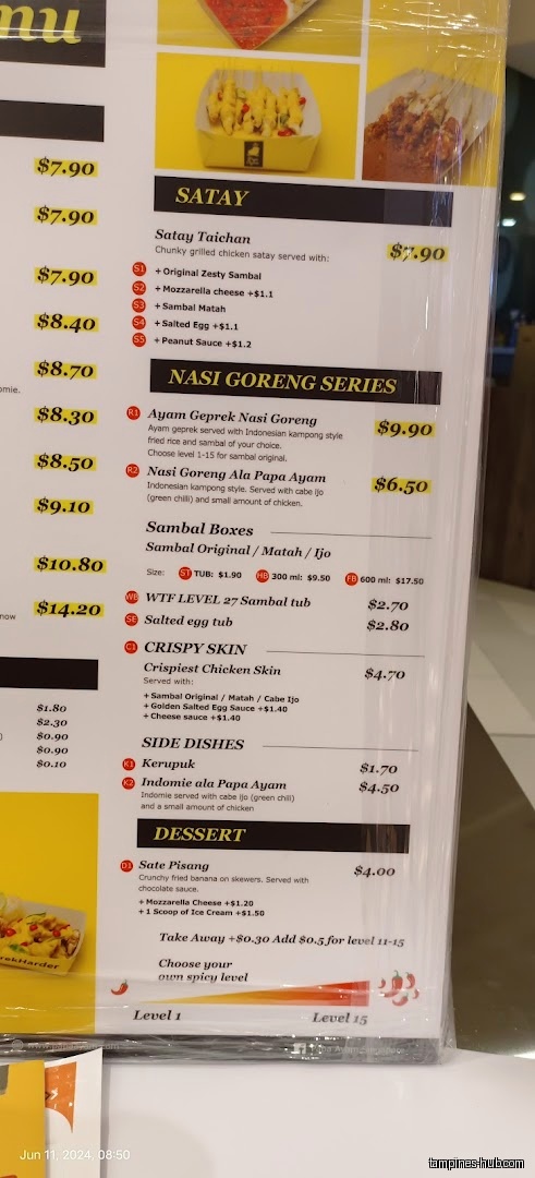 A menu board from Papa Ayam Our Tampines Hub showing food items and prices.