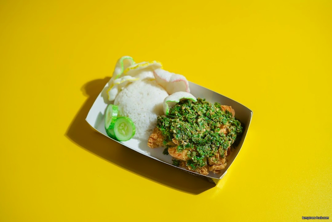 Ayam Geprek with rice, crackers, and cucumber on a yellow background.