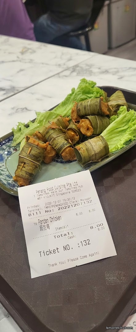 Pandan chicken on a plate with lettuce and a receipt.