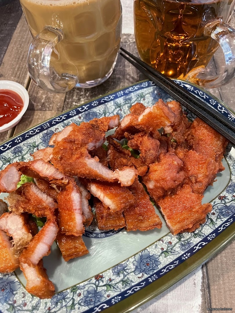 Fried pork belly on a plate with drinks and dipping sauce.