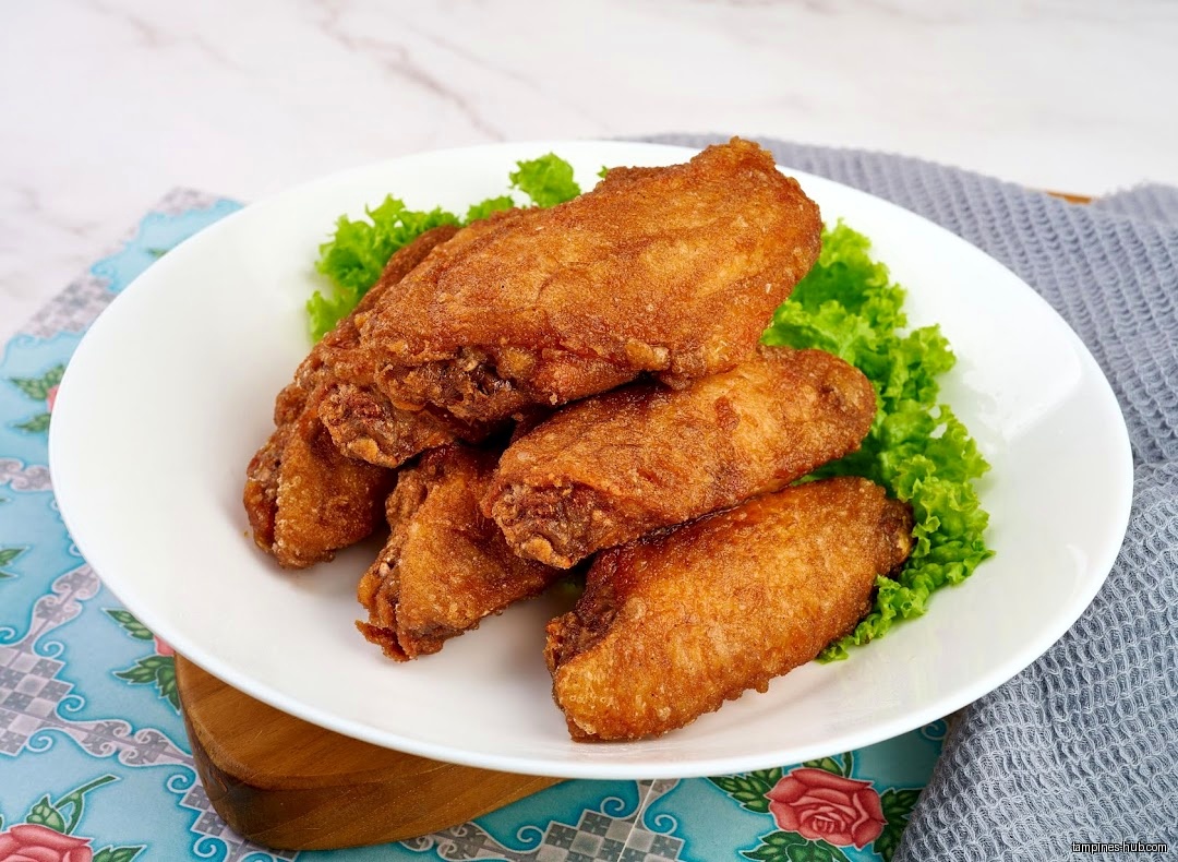 A plate of fried chicken wings with lettuce garnish is displayed.