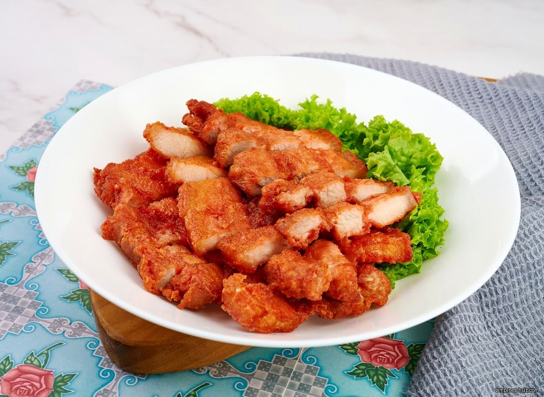 A plate of fried pork belly with lettuce garnish is shown.