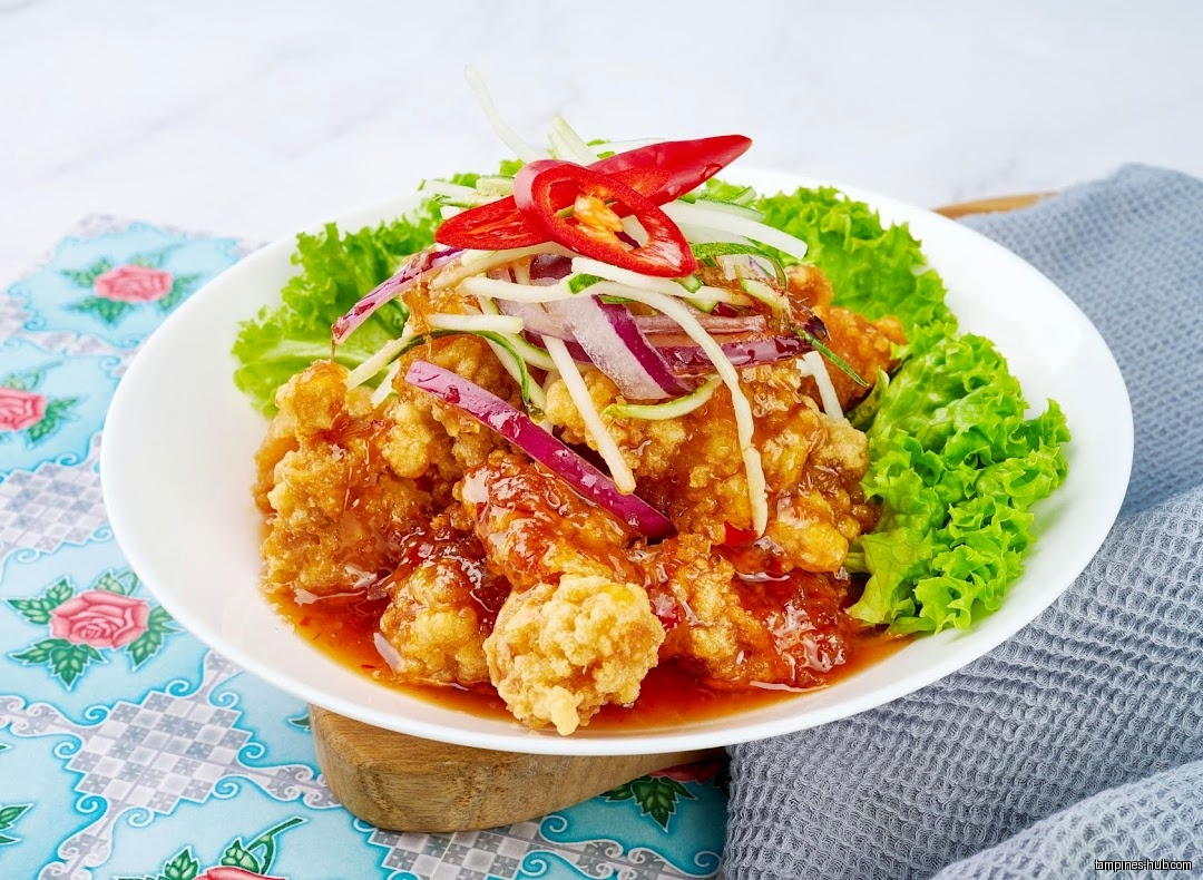 A plate of fried chicken with a sweet and sour sauce.