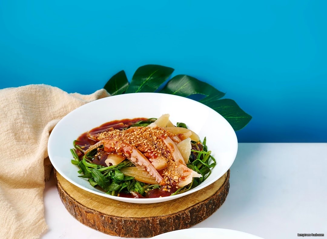 A plate of Penang Savour's food with vegetables and sauce.
