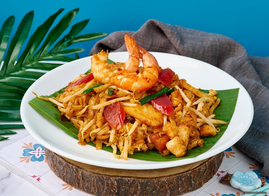 A plate of Penang Char Kway Teow with shrimp and other ingredients.
