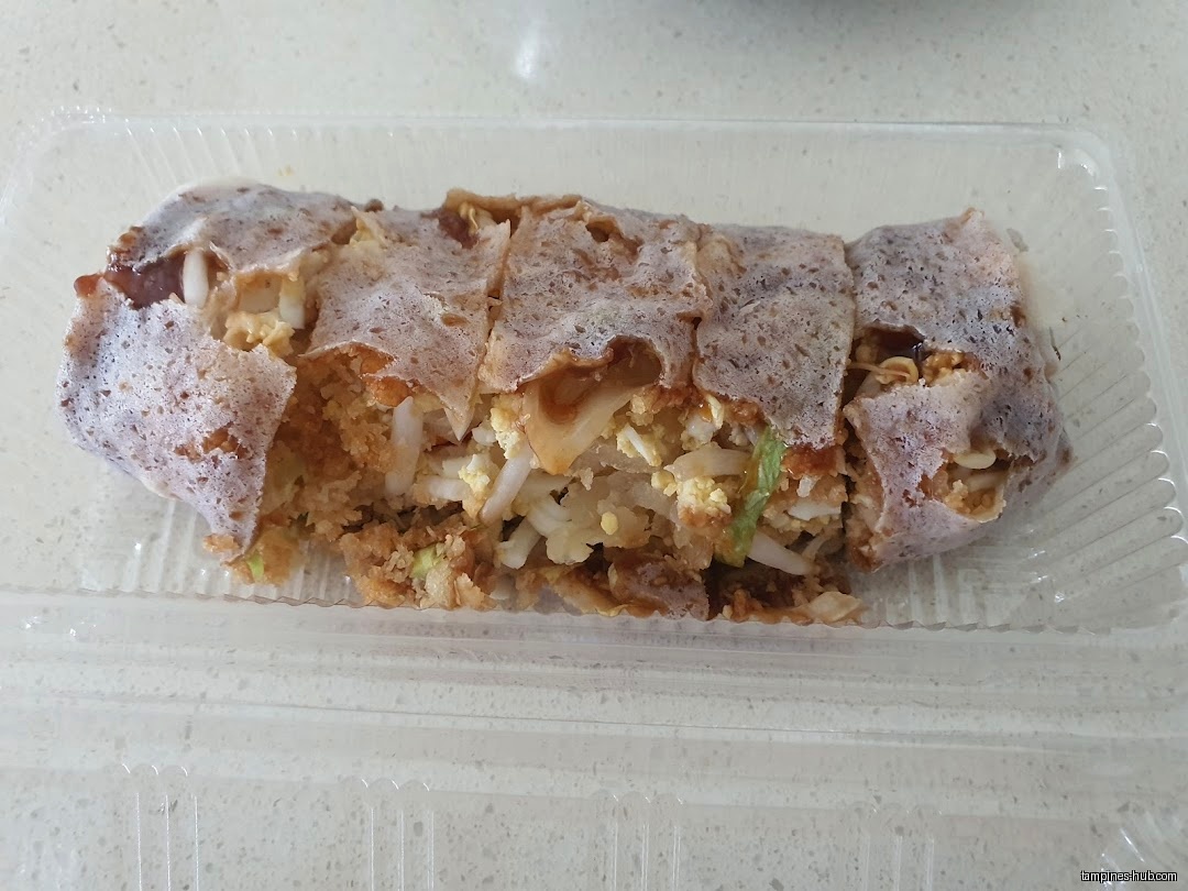 A popiah roll cut into pieces in a clear plastic container.