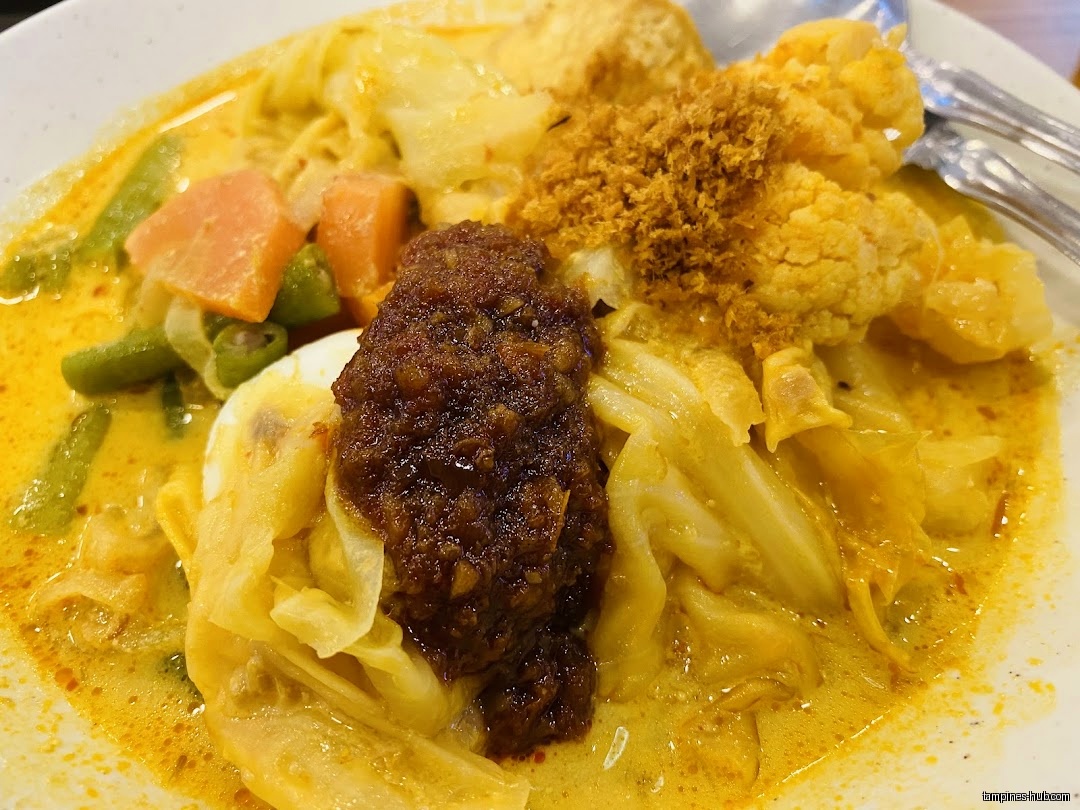 A close-up shot of a plate of Lontong, a Southeast Asian dish.