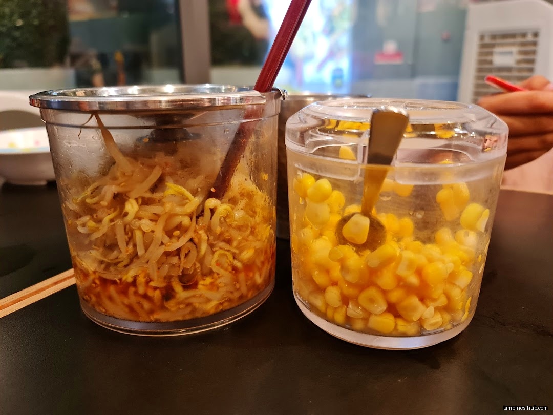 Two containers hold bean sprouts and corn, likely as ramen toppings.