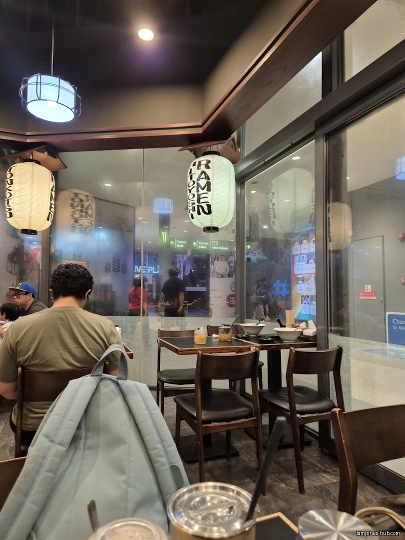 Interior view of Ramen Hitoyoshi with tables, chairs, and customers.