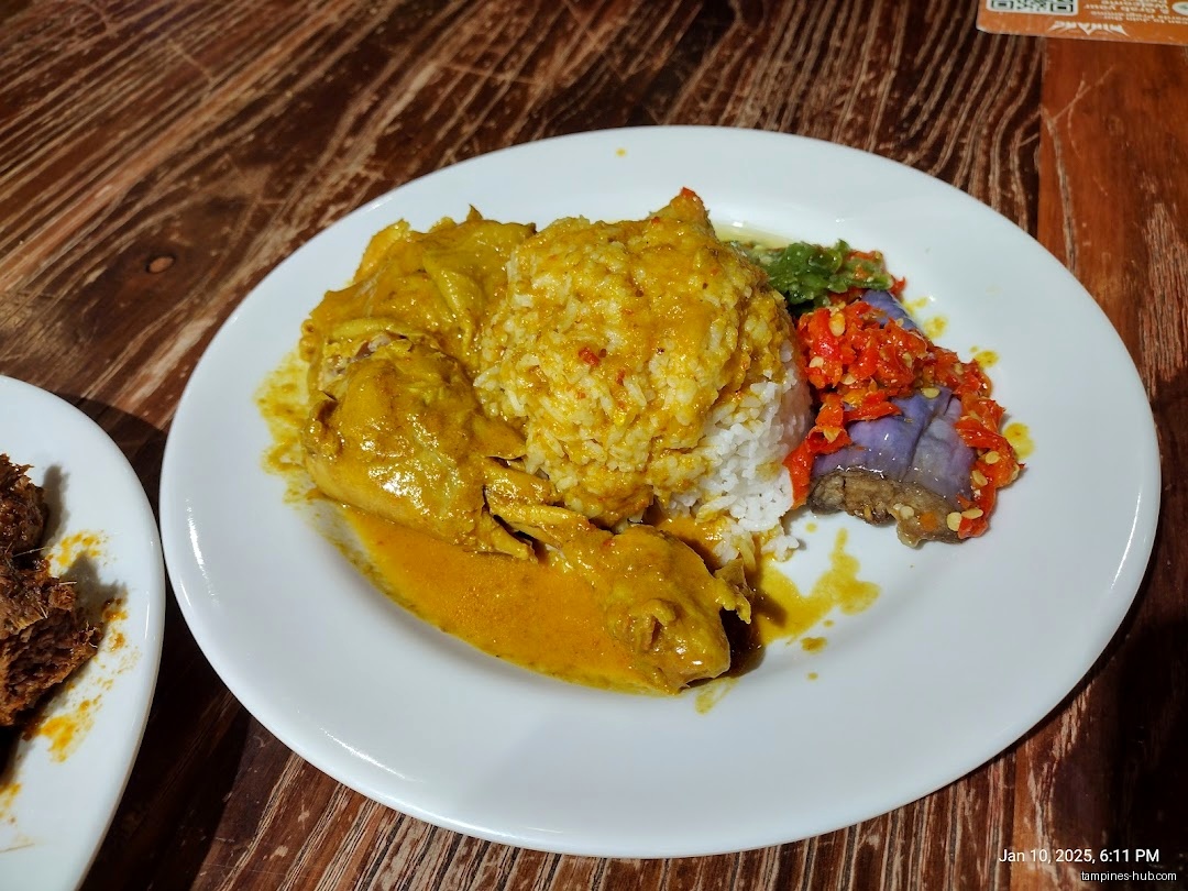 A plate of Nasi Padang with chicken curry and eggplant sambal.