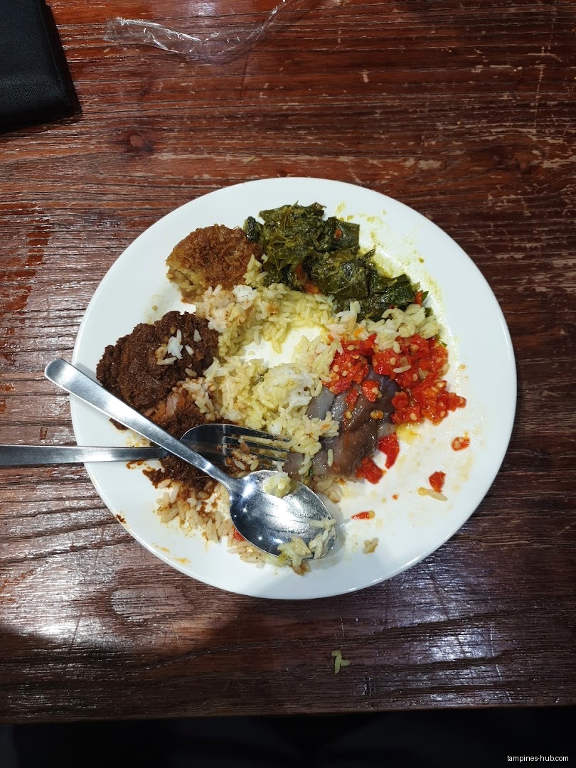 A plate of rice with various dishes, including meat and vegetables.
