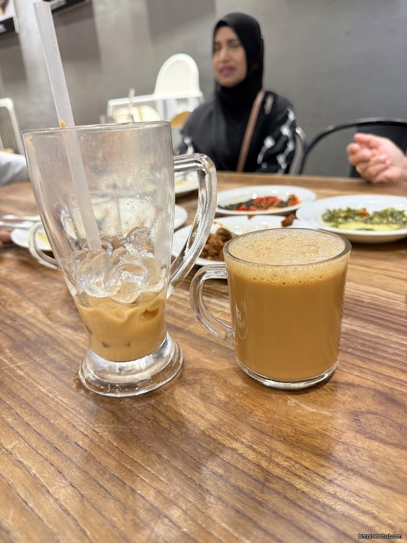 Drinks and food on a table at Rumah Makan Minang restaurant.
