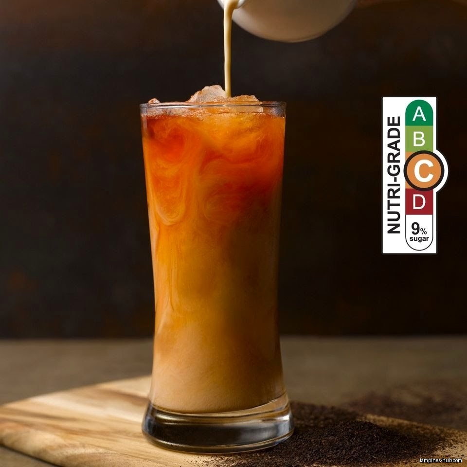 Thai milk tea being poured into a glass with a nutri-grade label.