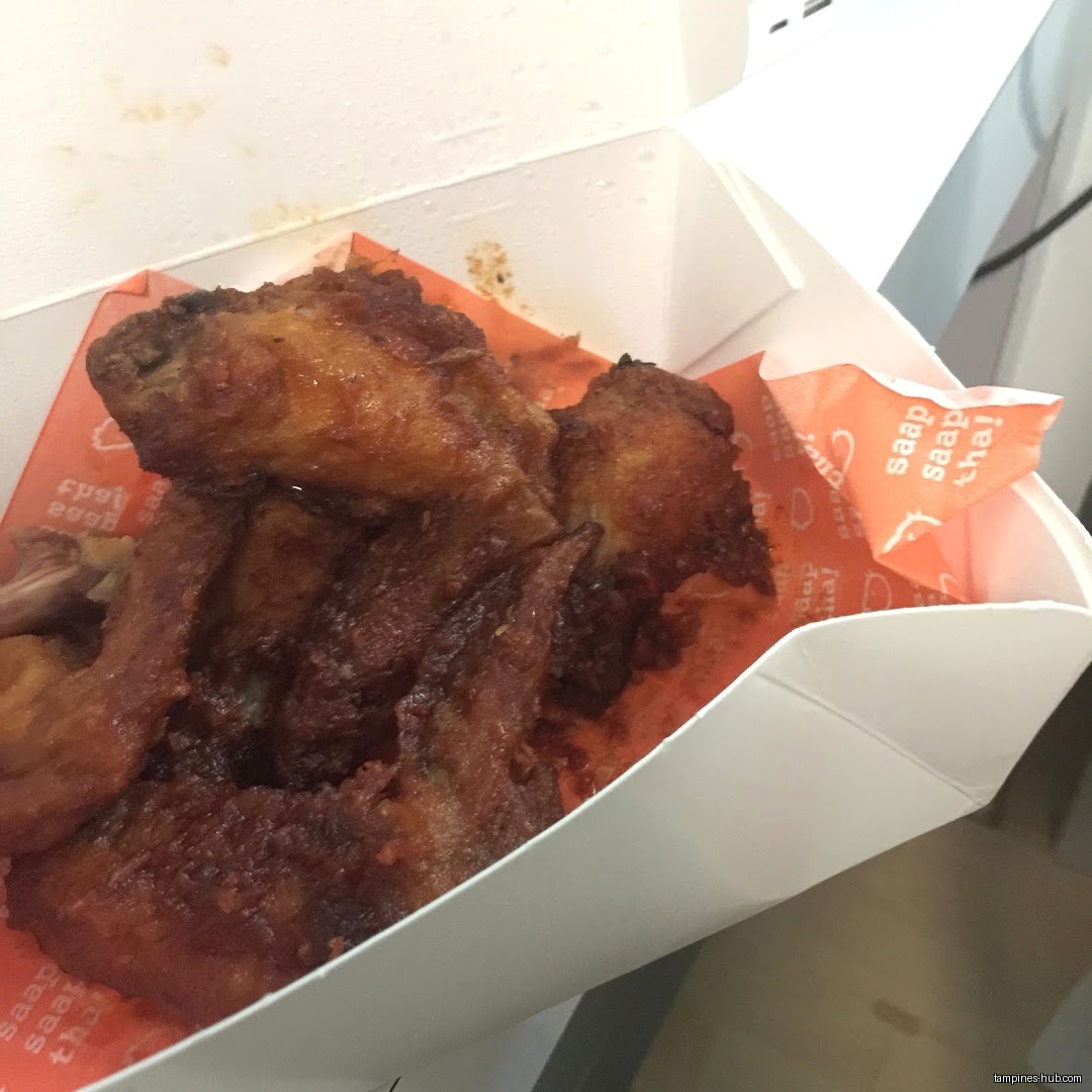 Fried chicken wings in a Saap Saap Thai branded takeout container.