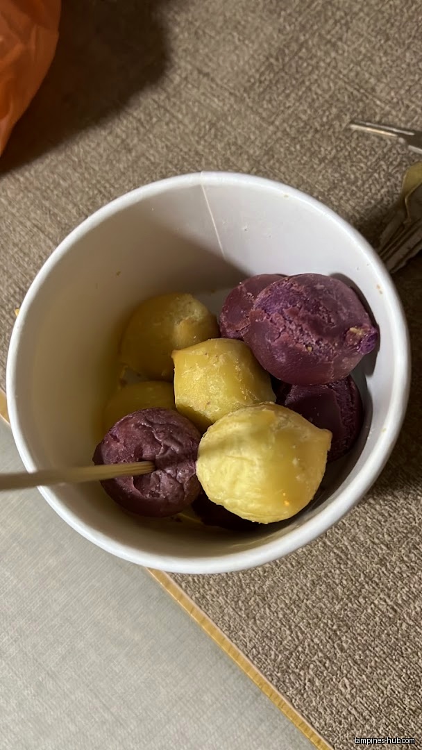 A white bowl filled with yellow and purple potato balls.