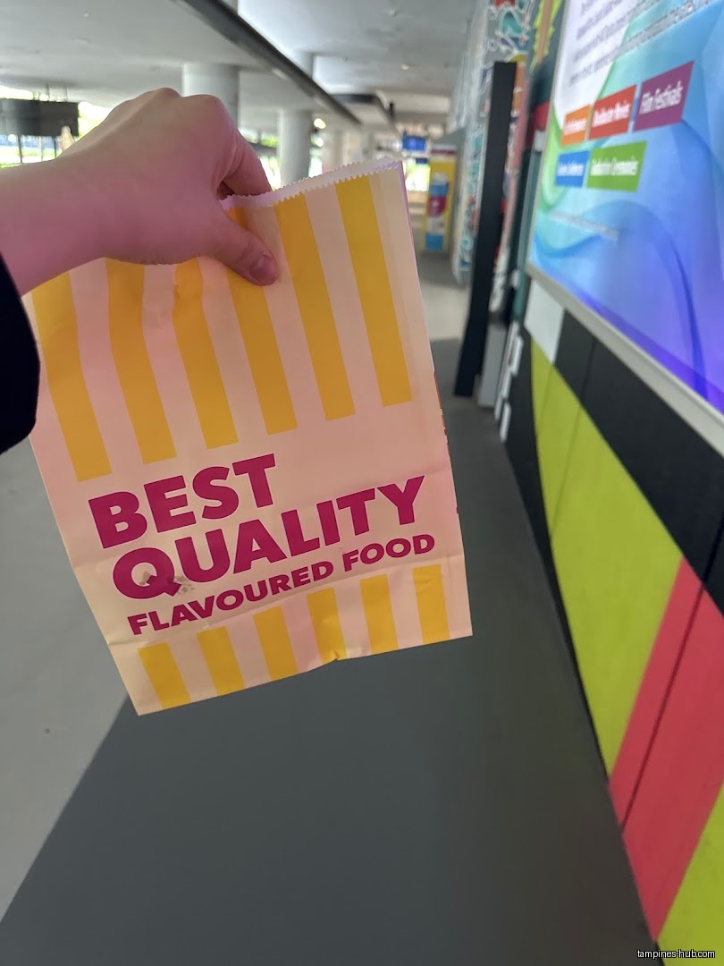 A hand holds a 'Best Quality Flavoured Food' bag from Shake Shake.