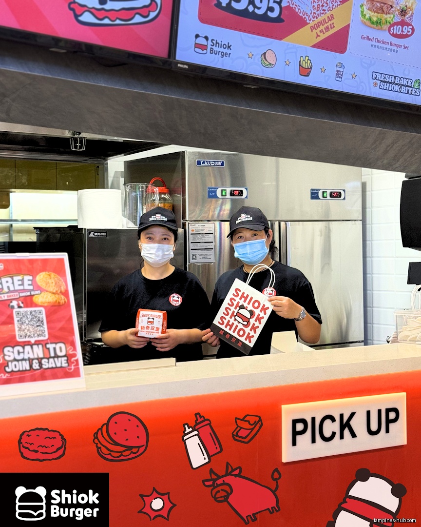 Two staff members stand behind the counter at Shiok Burger.