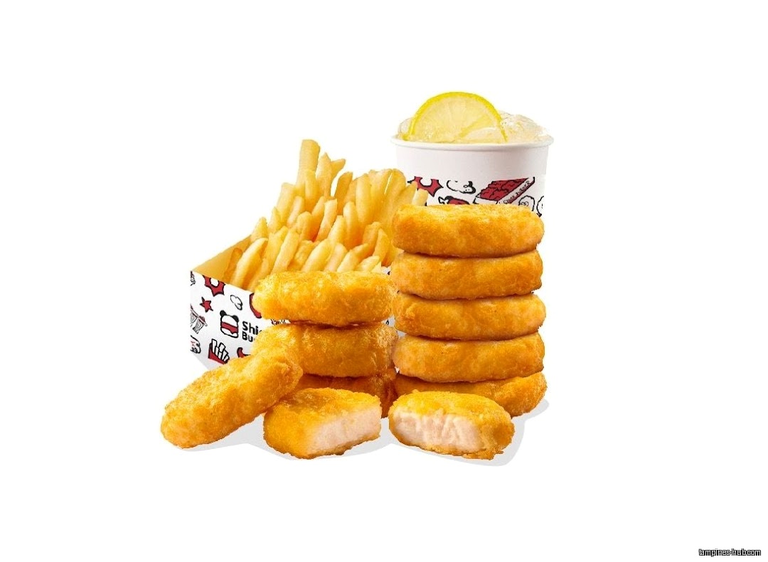 Image shows a stack of chicken nuggets, fries, and a drink.