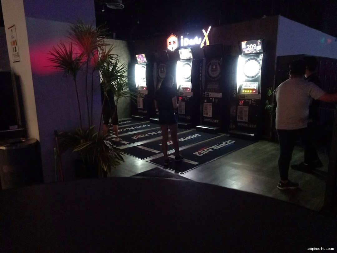 The image shows people playing darts at Sonic Bowl @ Our Tampines Hub.