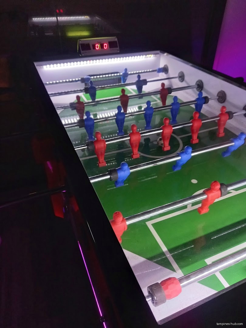 A close-up of a foosball table with red and blue players.