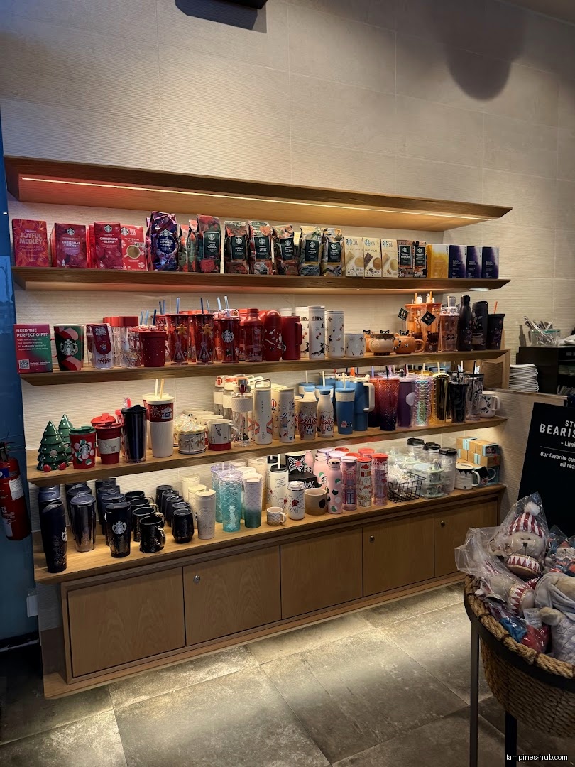 Starbucks display shelves filled with coffee beans, mugs, and tumblers.