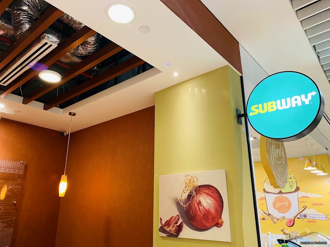 Interior view of a Subway restaurant with signage and onion artwork.