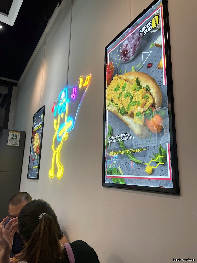 The image shows interior wall decor with menu posters and a neon sign.