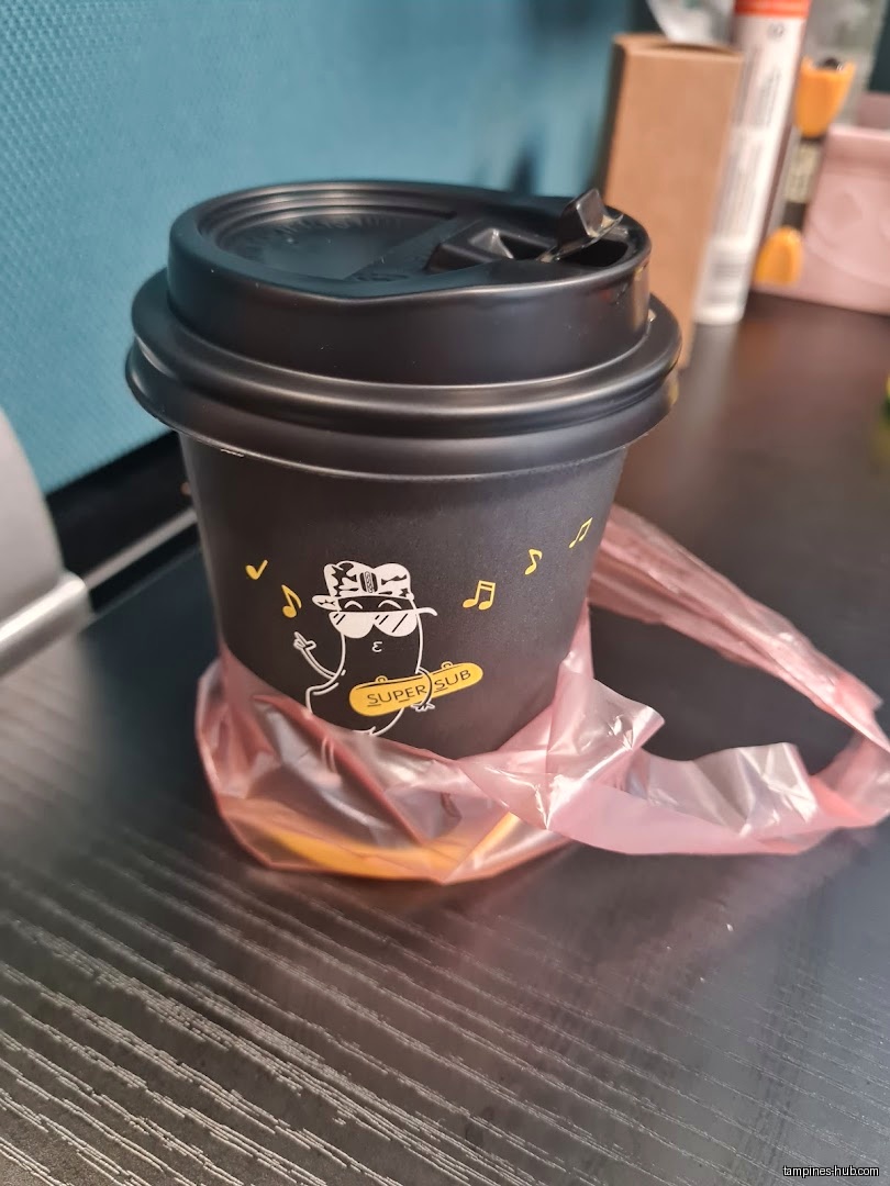 A black coffee cup from Super Sub Hotdogs & Coffee in a plastic bag.