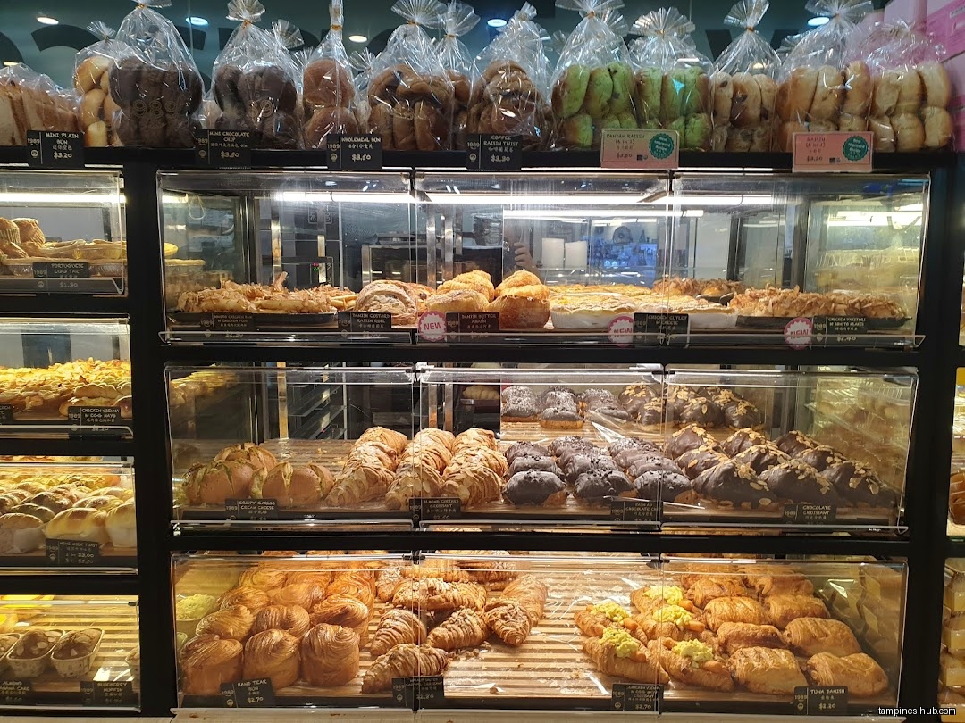 A display case filled with various breads and pastries at Swee Heng 1989 Classic.