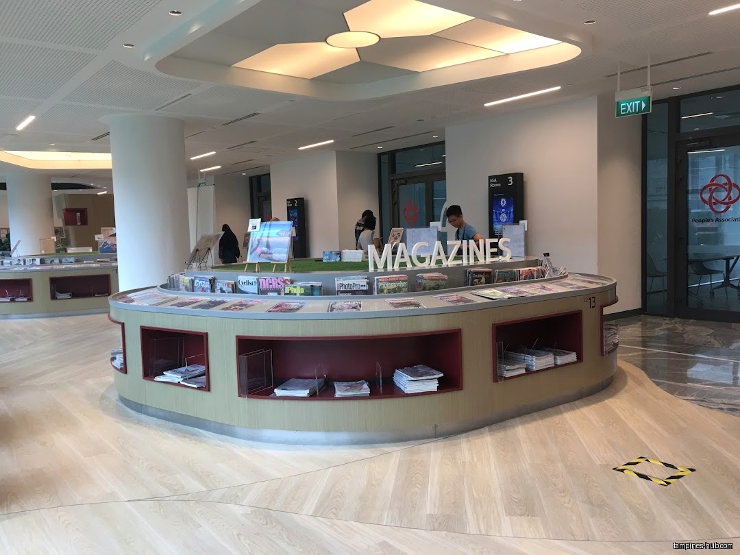 Interior view of Tampines Regional Library with magazine display and people.