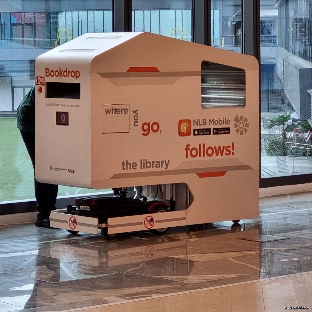 A mobile bookdrop with NLB Mobile advertisement is seen inside the library.