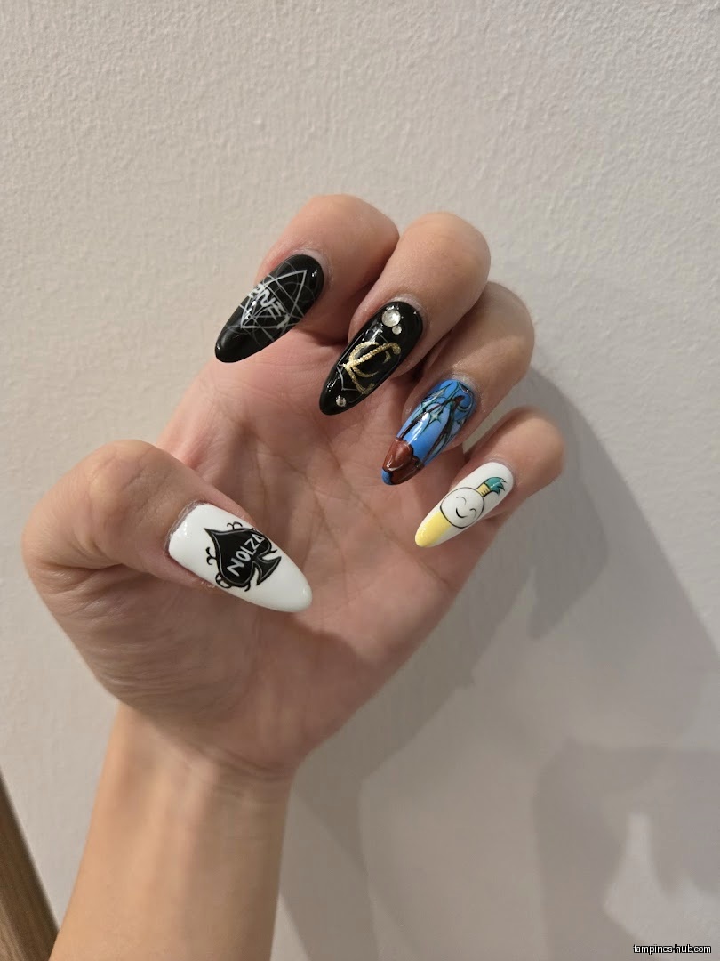 A hand with long, decorated nails is displayed against a plain background.